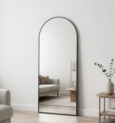 Grand miroir arche noir posé au sol dans un salon.