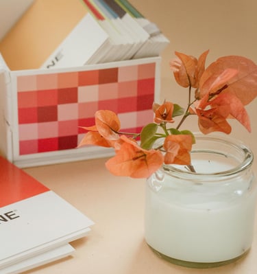 Flowers in a jar near Pantone color swatches box