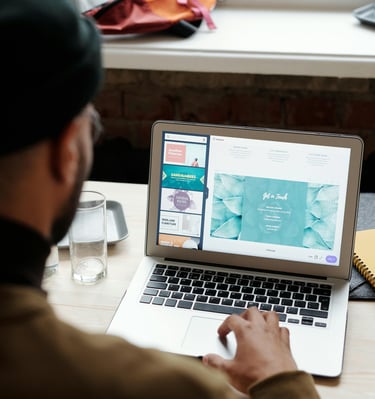 Black man with glasses review website design ideas on a laptop