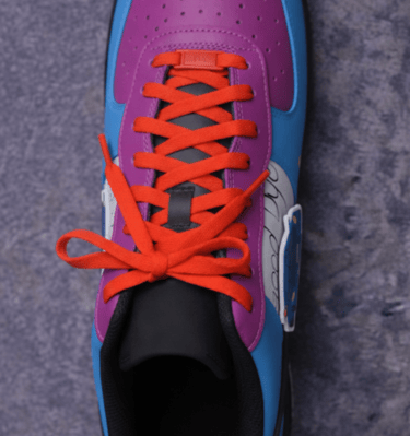 a pair of sneakers with orange laces and red laces