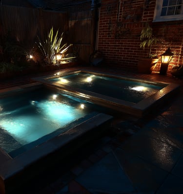 Illuminated luxury backyard swimming pools with underwater LED lights and outdoor garden lighting.