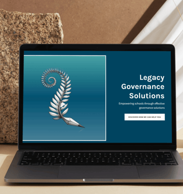 a laptop computer sitting on a table with a vase with the website legacy governance solutions on it