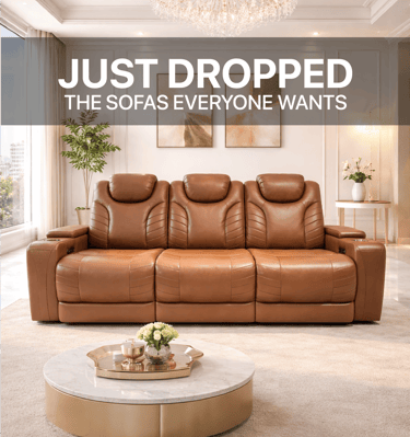 Luxury brown leather reclining sofa in a modern living room with a marble coffee table and chandelier.