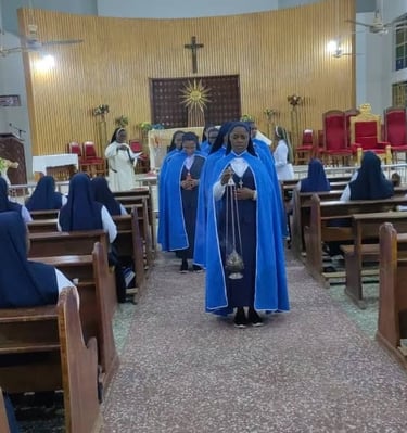 Catholic nuns in blue habits processing through a church aisle during a religious mass ceremony.