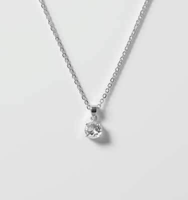 Elegant silver necklace featuring a round solitaire diamond pendant on a delicate chain.