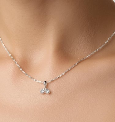 Elegant sterling silver necklace with a sparkling double diamond pendant worn on a woman's neck.