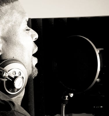Dr. Marlon Ware standing in front of a microphone with headphones on his ears
