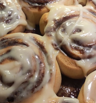 a pan of cinnamon cinnamon rolls with icing