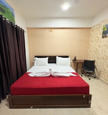 a bed with a red bed and a desk with a computer