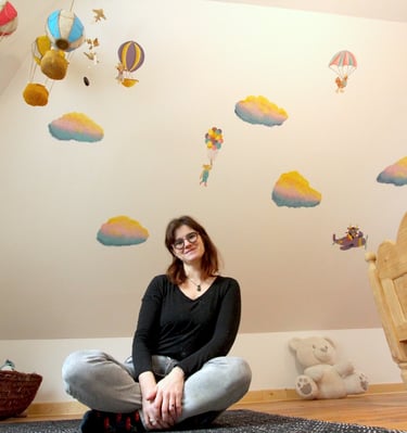 artiste Marie Hardy devant peinture murale en couleurs chambre enfant Aunay sur Odon Caen Normandie