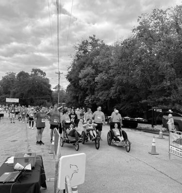 Black and White photo of Ainsley's Angles wheelchair runners lined up at the starting line of a race