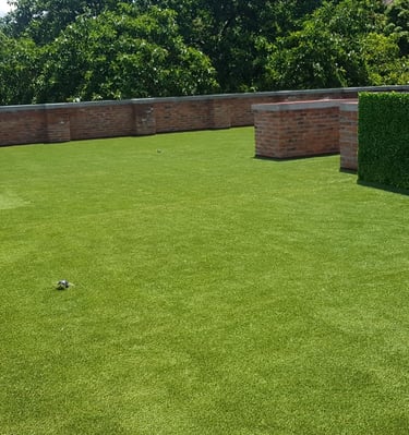 Pasto sintético verde instalado en jardín residencial en Guadalajara