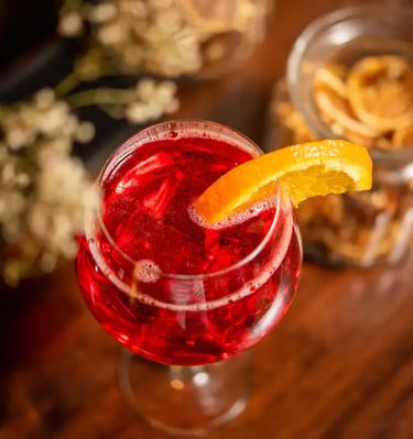 Un cocktail spritz avec un tranche d'orange sur un bar