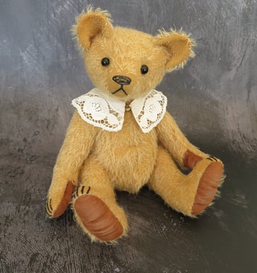 a handmade teddy bear wearing a lace collar