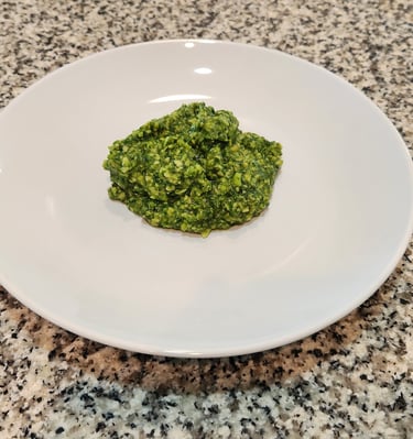 a plate on a counter with pesto