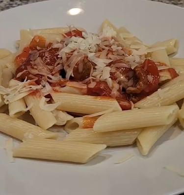 a plate on a counter with noodles with sauce