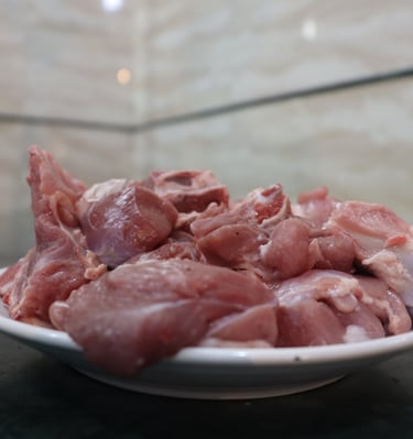 a bowl of raw meat curry cut on a counter top