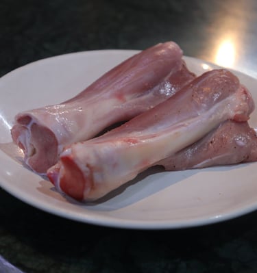 a plate of raw meat nalli piece of meat on it