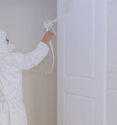Pintor profesional aplicando pintura en puertas con airless.