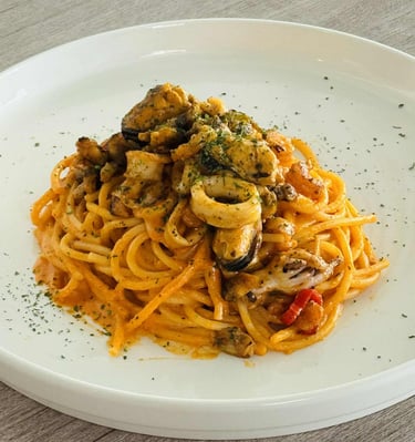 Italian seafood spaghetti served with mussels, squid, and herbs in a creamy tomato sauce 