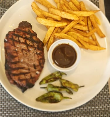 Grilled steak served with French fries and smoky barbecue sauce on a stylish wooden platter 