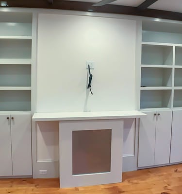 a room with a large white cabinet and a window