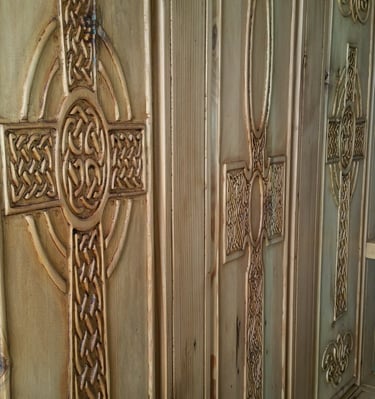 back panel of handcrafted monks bench.  Three carved panels featuring intricate Celtic knot crosses. Colorado Springs.