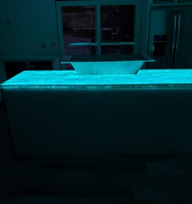 Kitchen remodel highlighting translucent quartz waterfall island countertop with color changing LED lights underlaid.  