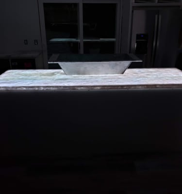 Kitchen remodel highlighting translucent quartz waterfall island countertop with color changing LED lights underlaid.  