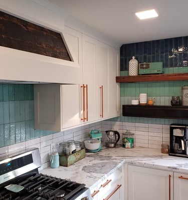 Renovated kitchen with custom vent hood, white and gray quartz counter tops, blue hombre tile work. Colorado Springs Kitchen.