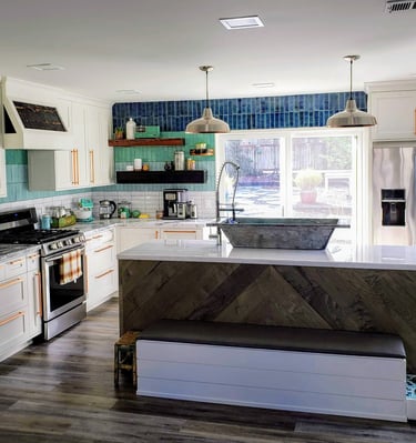 After picture of fully remodeled kitchen.  Custom cabinetry, custom counters, waterfall edge island, blue hombre wall tile.