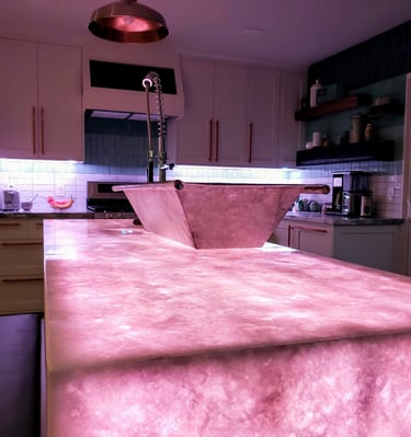 Kitchen remodel highlighting translucent quartz waterfall island countertop with color changing LED lights underlaid.  