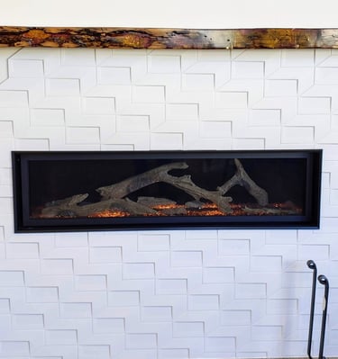 Reclaimed wood and epoxy mantle with wormwood pattern.  Modern gas fireplace with geometric tile work surround. El Paso, CO.
