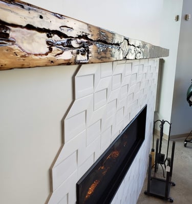 Reclaimed wood and epoxy mantle with wormwood pattern.  Modern gas fireplace with geometric tile work surround. El Paso CO.