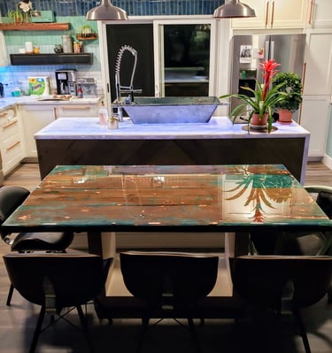 modern kitchen with smart colored lights under island counter.  Custom French bath sink and custom wood and epoxy table.