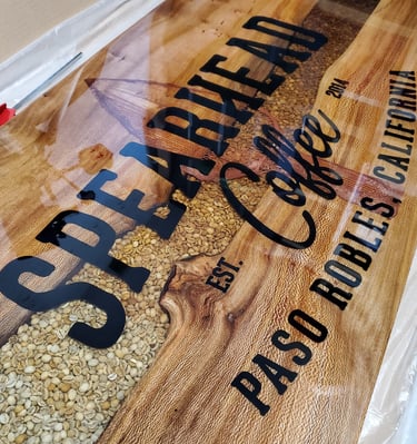Custom live edge and resin river table top. Coffee beans fill the river with a logo CNC'd in the epoxy. 