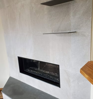 Sleek gas fireplace surround with slate shelves and hearth. Colorado Springs fireplace remodels.