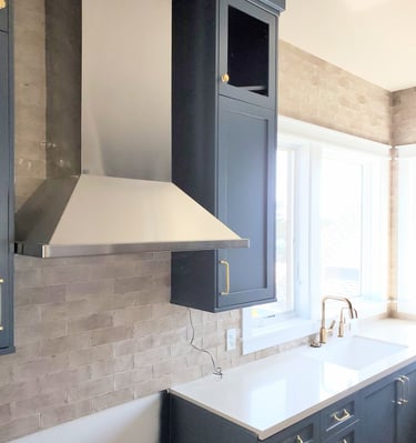 Remodel of kitchen.  Vent hood, black cabinetry, and white counter tops. Colorado Springs.