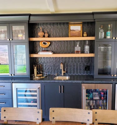 Custom black cabinet wet bar with glass paneled doors and custom natural wood shelving. Colorado Springs carpentry.