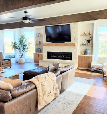 Living room remodel with exposed beams, white stone work fireplace with natural wood mantle.