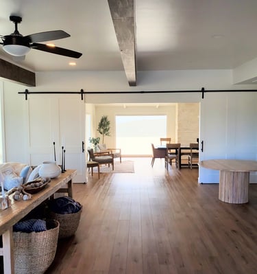 living room into dining room with custom sliding barn doors to separate.  custom beams on the ceiling. Colorado Springs.