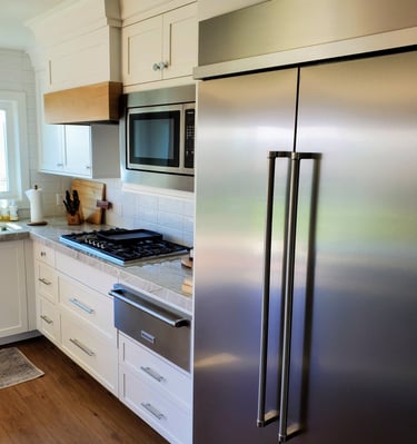 Remodeled kitchen with quartz countertops, white cabinetry with built in oven.  Custom space for stainless fridge. El Paso CO