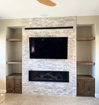 stone work fireplace surround with large mounted TV.  Custom shelving on either side. Colorado Springs fireplace updates.