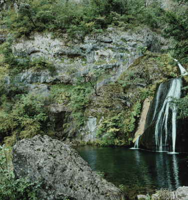 a waterfall in a canyon with a waterfall in the background