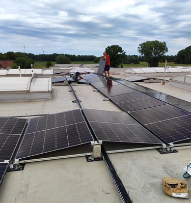 a man standing on a roof top with solar panels