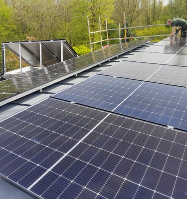 a man standing on a roof top with solar panels