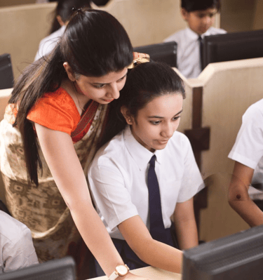 Student learning digital skill at Smart Village Computer Hub. Instructor teaching. 