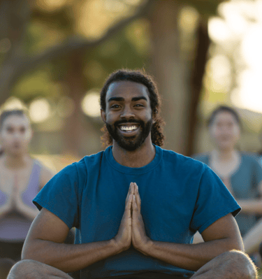 a man in a blue shirt sitting in a pose of gratitude