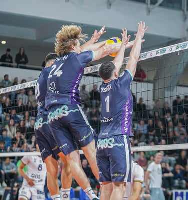 Trois bloqueurs du Paris volley et un ballon qui passe entre les mains de celui du milieu