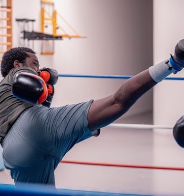 Boxeur qui essaye de mettre un coup de pieds dans la tête de son adversaire